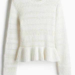 Vit stickad tröja med volang - Supersöt vit stickad tröja från H&M med volangdetalj nedtill. Tröjan har långärmade armar och ett snyggt hålmönster som ger en cool och trendig vibe. Perfekt att styla med jeans eller kjol för en chill look. Nästan aldrig använd 