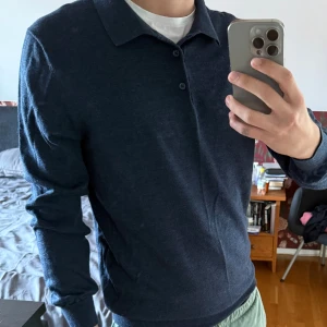 Mörkblå pikétröja John Henric L - Säljer en stilren mörkblå pikétröja från John Henric i storlek L. Tröjan har lång ärm, klassisk krage och två knappar framtill. Materialet är mjukt och stickat, perfekt för dig som gillar en clean och enkel look.