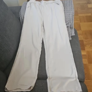 Beigea linnebyxor  - Säljer ett par beigea byxor med bred passform och elastisk midja med snörning. 