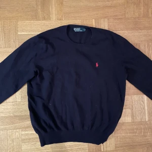 Mörkblå kashmir tröja från Polo Ralph Lauren - Mörkblå kashmir tröja från Polo Ralph Lauren med klassisk rund hals och röd broderad logga på bröstet. Ett mycket bra pris med tanke på det fina skicket tröjan är i samt vad nypriset är.✅