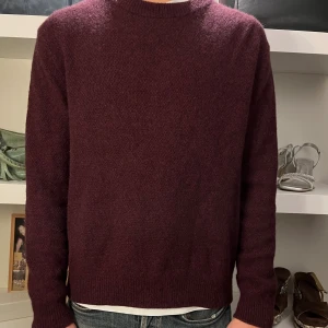 Stickad tröja  - Vi säljer den här tröjan i snygg vinröd färg. Perfekt till hösten! Storlek L men passar vår modell som är 180 cm och har storlek S/M.