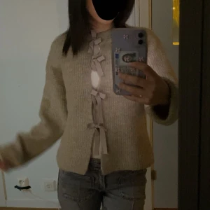 Beige stickad kofta med rosetter - Jätte fin och nästan helt ny, använd 3-4 gånger