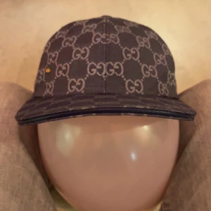 Gucci keps med GG-mönster - Snygg keps från Gucci i mörkblå med det klassiska GG-monogrammet över hela kepsen. Skärmen är böjd och materialet är kraftig bomullscanvas. Perfekt för dig som vill ha en exklusiv och trendig accessoar med tydlig logga.
