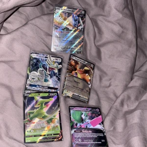 Pokémon GX/V Kort - 5-pack - Samling med fem Pokémon-kort: Archaludon GX, Drampa GX, Kangaskhan GX, Virizion V och Iron Valiant EX. Perfekt för dig som vill boosta din samling med coola och glittriga kort! Passar både samlare och spelare som älskar Pokémon.