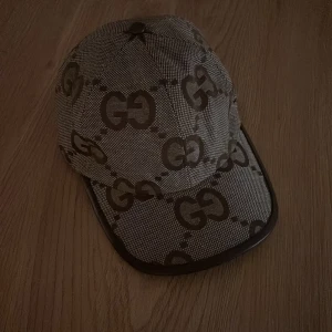 Gucci keps - Snygg beige Gucci keps. Den köptes ett tag sen men är inte använd, väldigt fräsch och passar bra på en outfit för att ge den en lyxig vibe!