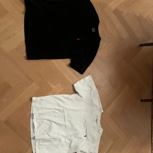 2-pack Polo Ralph Lauren t-shirts S - Två klassiska t-shirts från Polo Ralph Lauren i storlek S, en svart med röd logga och en vit med svart logga. Båda har rund hals, kort ärm och är i skön bomull med slim fit-passform. Perfekta basplagg med stilren design och diskret broderad logga på bröstet. Andra bilden på den svarta loggan fick inte plats på bilderna men det är bara att komma privat för den.
