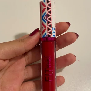 Rött flytande läppstift Fit Me! 211 - Säljer ett intensivt rött flytande läppstift från Fit Me! i nyansen 211. Kommer i en snygg tub med grafiskt mönstrad vit kork i rött, blått och svart. Perfekt för dig som gillar färgstarka läppar.