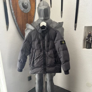 Stone Island vinterjacka - Säljer en svart/grå vinterjacka  från Stone Island med ikonisk patch på ärmen. Jackan har hög krage, flera fickor med dragkedja och en clean, modern look. En otroligt fin jacka som jag köpte förra vintern och är otroligt skönt samt klarar av mycket kyla. Nypris 9000kr, hör av er vid minsta fundering och PRIS kan diskuteras!