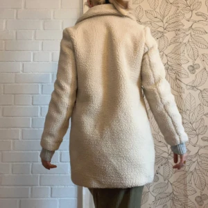 Teddykappa - Fluffig teddy-kappa från Vero Moda i storlek S. Ny med lapp kvar. Nypris 650kr. Den har ett tillhörande fuskläder-skärp som också följer med, men jag personligen föredrar kappan utan det.  Kolla gärna in mina andra artiklar också för en Bundle-rabatt😊