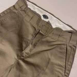 Beiga Dickies chinos W26 - beiga chinos från Dickies med raka ben och normal passform. Jättefint skick! skriv för fler frågor eller bilder💗