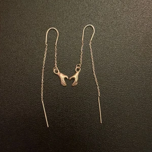 Silvriga örhängen  - Unika och tunna silvriga örhängen med kedja och små hängande händer som detalj. 