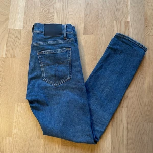 Blå Tiger of Sweden Pistolero jeans W29 L32 - Jag säljer dom här riktigt snygga jeansen från Tiger of Sweden i storlek W29 L32. Modellen heter Pistolero. De är inte använda mycket alls och är i fint skick utan skador. Tveka inte att höra av er!                                                                           Mått: längd=101cm. Midja=40cm