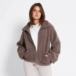 Brun teddyjacka med dragkedja - Mysig brun teddyjacka med hög krage och dragkedja framtill. Jackan har en loose passform och är tillverkad i fluffigt teddy-material. Perfekt för kyliga dagar och enkel att styla till olika outfits.