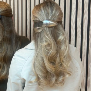 Silver hårklämma  - Snyggt och stilren hårklämma i silver. Perfekt för att ge frisyren en modern touch. Oval form som sitter stadigt. Gjort av återvunnet tyg och skedar!