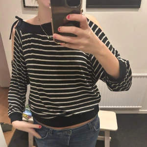 Randig svartvit tröja med knyt - Jättefin tröja med knutar och öppna axlar. Står ingen storlek men skulle säga att den är i strl S☺️