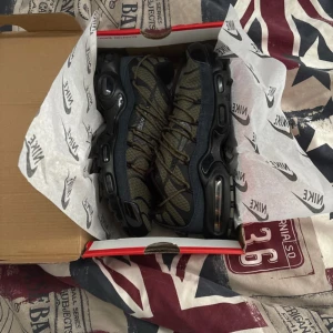 Nike Air Max Plus i olivgrönt och svart - Säljer ett par Nike Air Max Plus sneakers i olivgrönt mesh med svarta detaljer och robust svart sula. Skorna har snörning och synliga Air Max-enheter i sulan för extra komfort. Perfekta för dig som gillar streetwear och vill sticka ut med en unik färgkombination.