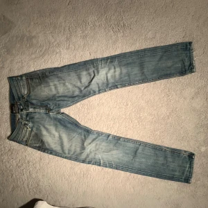 Acne Jeans ljusblå slim jeans - Ljusblå jeans från Acne Jeans. Jeansen har slitningar och en tydlig broderad cirkel på bakfickan. Tillverkade i denim av bomull och har en snygg tvättad look. 28/32 