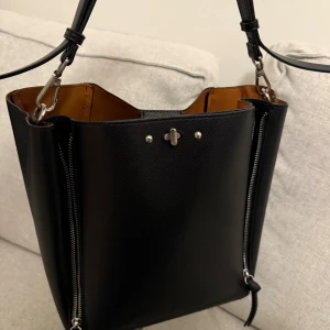 Handväska från ZARA - Populär handväska från Zara som inte går att köpa längre. Sparsamt använd. Dragkejdorna kan dras upp så får väskan en annan look.