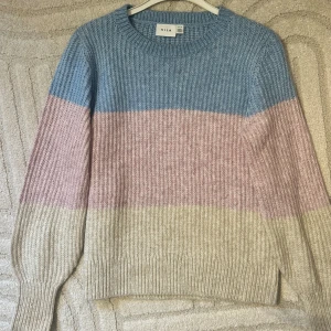 Stickad tröja  - Stickad tröja från Vila i ljusrosa, beige och ljusblå. Storlek XS. Mycket fint skick, få tecken på användning. 