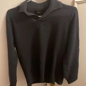 Svart ulltröja med krage Massimo Dutti - Svart långärmad tröja från Massimo Dutti i ren ull. Klassisk krage och enkel design som funkar till många olika stilar. Perfekt för kyligare dagar och enkel att matcha med jeans eller kostymbyxor.