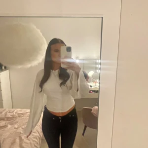 Vit långärmad från nelly - Säljer en vit långärmad topp med  lätt utsvängda ärmar. Toppen har en enkel, stilren design och är tillverkad i mjukt bomullsmaterial. Perfekt att matcha med jeans eller kjol för en clean look. Den har ett lite hål men inget man lägger märke till.