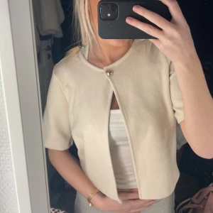 Beige cardigan kortärmad  - Beige cardigan, kofta? vet inte vad man ska kalla det men går till armvecket och är från gina tricot! nypris 299kr💗använd 1-2ggr