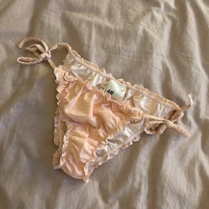 Ljusrosa bikiniunderdel med volang - Supersöt ljusrosa bikiniunderdel från H&M med volangdetaljer och knyt i sidorna. Storlek 34💗