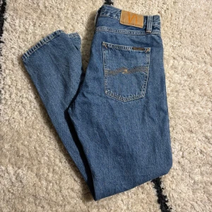 Jeans från Nudie - Säljer dessa riktigt snygga blå jeans från Nudie. Dem är i modellen Steady Eddie II och sitter lite vidare men behåller fortfarande en snygg taper ner mot byxans änd. Den är i storlek W30 och L30, modellen är 181cm lång och väger 73kg. Nypris 1600, tveka inte vid frågor eller prisförslag👖🌂💼.