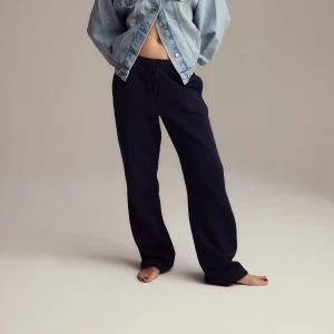 Mörkblå mjukisbyxor med resårmidja - Säljer ett par mörkblå mjukisbyxor med avslappnad passform och resår i midjan. Byxorna har raka ben och är tillverkade i mjukt material som känns skönt mot huden. Perfekta för chill dagar eller när du vill vara bekväm.