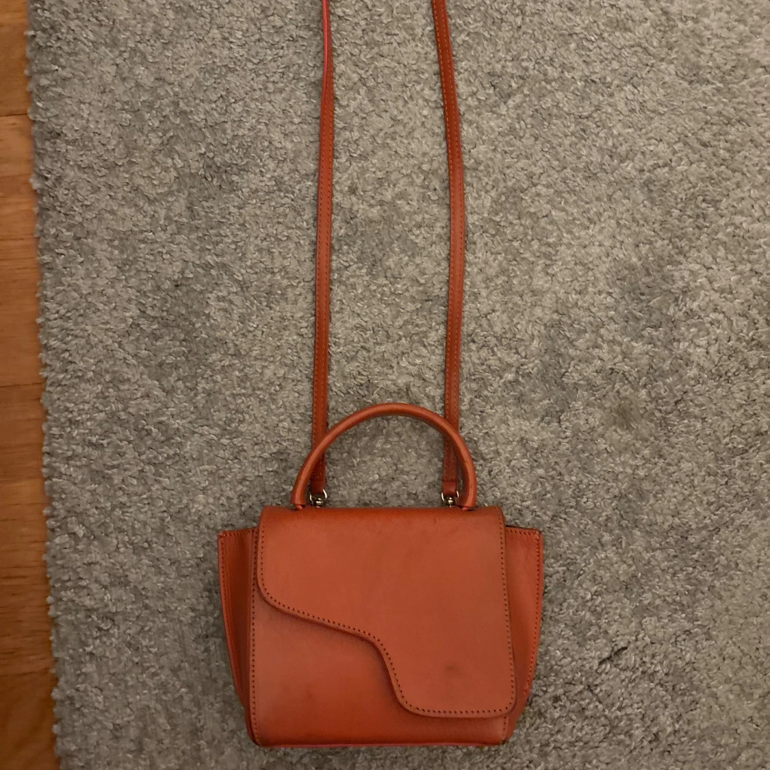 Orange axelväska i skinn med unik form