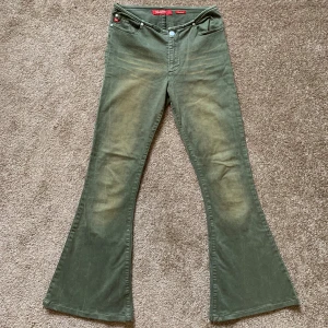 Vintage Miss Sixty khaki utsvängda jeans - Suuuuuper snygga vintage Miss Sixty jeans med utsvängda passform och låg midja. Materialet är robust bomull och färgen är dämpad grön med slitningar.
