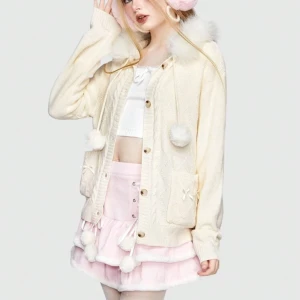 Söt cremevit kofta med fuskpäls och huva - Supergullig cremevit kofta med fluffig fuskpäls runt huvan, stora knappar och två fickor med små rosetter. Stickad struktur, dekorativa bollar i snörena och relaxed fit. Perfekt för dig som gillar kawaii eller cozy vibes.