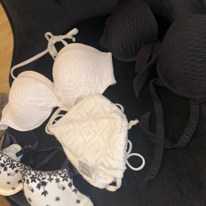 Bikini toppar - Säljer bikinitoppar & en behå. Vit spets bikini, storlek M (utan bygel) Svart bikini med push up, storlek: 80B. En vit bikini topp och en svart bandeau-topp. Några har knytband och fina strukturer. Bh, storlek: 75B.
