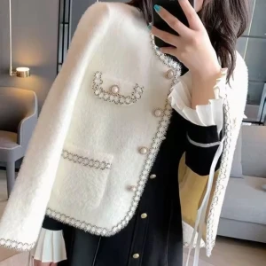 Vit cardigan jacka med pärl knapp - Superfin vit cardigan jacka med pärlknappar och dekorativa pärldetaljer längs kanterna och fickorna. Jackan har rund halsringning, två bröstfickor och två vanliga fickor framtill. Mjuk och fluffig känsla, perfekt för att lyfta din outfit.