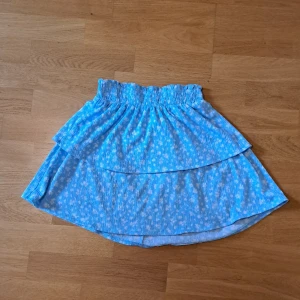 volangkjol från H&M  - Supersöt blå kjol från H&M i storlek XS med små vita blommor och volangdetaljer. 