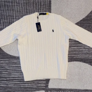 Vit kabelstickad tröja Polo Ralph Lauren - Är du 175 och vill att tjejer ska märka denna tröja så är denna vackra tröja så är den perfekt för dig Vit kabelstickad tröja från Polo Ralph Lauren med klassisk rund hals och broderad logga på bröstet. Tröjan har lång ärm och ribbade muddar. Perfekt för lager-på-lager och snygg till jeans eller kjol. Pris kan diskuteras vid snabbaffär!!