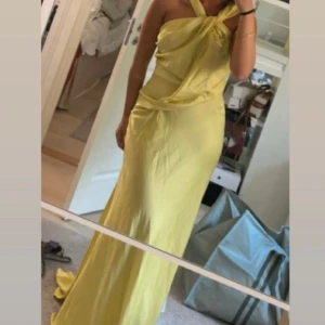 Gul långklänning med omlott och knyt - Säljer en superfin gul långklänning med omlott-detalj och snygg knytning vid halsen. Aldrig använd. Storlek 36. Pris 600. Köpt ifrån asos, slutsåld.