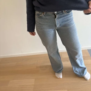 Levi's 501 ljusblå raka jeans - Klassiska Levi's 501 jeans i ljusblå tvätt med raka ben och hög midja. Jeansen har fem fickor, knappgylf och är tillverkade i robust denim. Perfekta för dig som gillar en tidlös och avslappnad look.