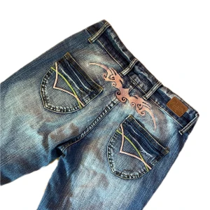 LÅGMIDJADE CRAZY AGE BOOTCUT  - Lågmidjade jeans från Crazy Age med bootcut. Jättebra skick! Så snygga med rosa detaljer både fram och bak. Står storlek 27, skulle säga att dem sitter som S. Skriv om du har frågor! :)