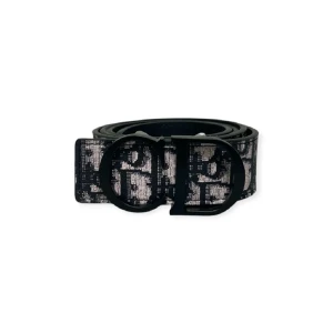 Svart och vit Dior bälte med logomönster - Snyggt bälte från Dior i svart och vitt med tydligt logomönster och en stor, svart spänne med CD-detalj. Bältet har en klassisk form och är tillverkat i skinn med canvasdetaljer. Perfekt accessoar för att lyfta din outfit.