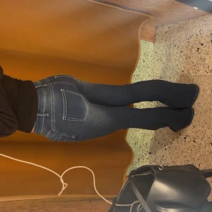 Blå bootcut jeans med stretch - Snygga blå jeans med bootcut-modell och markerade sömmar. Jeansen har en klassisk femficksdesign, dragkedja och knapp framtill samt stretchigt denimtyg som sitter tajt över låren och släpper ut vid vaden. Perfekta för dig som gillar en trendig siluett.