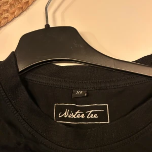 Svart t-shirt Mister Tee XS -              PRIS går att diskuteras vid snabbt köp .                        Svart t-shirt från Mister Tee i storlek XS med ett stort tryck framtill som föreställer en boxningsmatch och texten 'It's Goin' Down'. Klassisk rund hals och korta ärmar. Perfekt för dig som gillar streetstyle och coola prints.