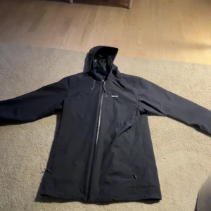 Mörkblå 2-i-1 jacka från Patagonia - Säljer en mörkblå 2-i-1 jacka från Patagonia. Ytterjackan är en stilren vindjacka med huva och dragkedja, medan innerjackan är quiltad med knappar.bröstet. Kom privat för bilder eller funderingar. Pris kan diskuteras, 2900 för båda/hela jackan eller 1400 för endast en av jackorna! Nypris 6000.