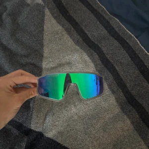 Sportiga gröna och blå solglasögon - Säljer ett par sportiga solglasögon med spegelglas i grönt och blått. Perfekt för Afterskin eller andra uteaktiviteter, aldrig använda. Bilden är på mina egna i samma modell. 