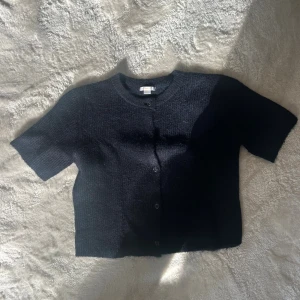 Stickad tröja  - Säljer en jätte fin mörkblå kortärmad stickad tröja från Gina Tricot. Den är i storlek 170 men passar även någon som har xs eller s! Använd en gång! 