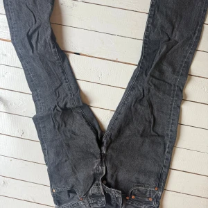Levi's 501 svarta jeans W30 L32 - Svarta Levi's 501 jeans med klassisk rak passform och femficksdesign. Jeansen har knappgylf, snygga kontrastsömmar och den ikoniska läderpatchen bak. Perfekta för dig som gillar en tidlös och clean look. Använda ca 5-10 gånger perfekt skick