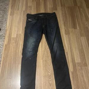 Diesel Jeans  - Snygga mörkblå jeans från Diesel med slitna detaljer och klassisk femficksdesign. Jeansen har en smal passform och subtila slitningar framtill för en cool look. Perfekta för dig som gillar stilrena men ändå trendiga jeans. Vid minsta fundering tveka inte på att höra av dig. Kan tänka mig att gå ner en slant i priset vid snabb och smidig affär👍