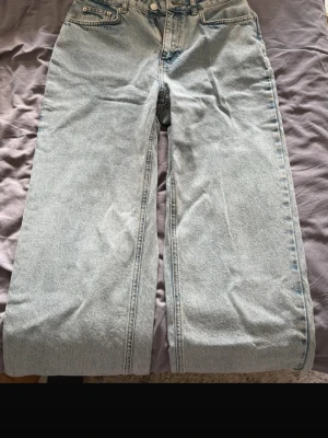 Ljusblå raka jeans med råa kanter - Säljer ett par OANVÄNDA ljusblå jeans med rak passform och råa, avklippta benslut. Jeansen har klassisk femficksdesign och hög midja. Perfekta för en avslappnad och trendig look. aldrig använda men legat i garderoben så tvättar före jag skickar! 