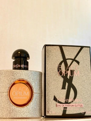 YSL Black Opium Glitter 30 ml - Yves Saint Laurent Black Opium Glitter Eau de Parfum. Enbart testsprayad ett fåtal gånger, vilket syns på bild. Enligt mig är detta den bästa Libre-flankern! Den är givetvis förvarad mörkt, svalt och torrt. Kommer i originalförpackningen,   Flaskan innehåller 30 ml. Batchkod 38Y900D.