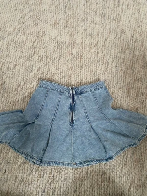 Lowwaist jeans kjol - Supersöt ljusblå jeanskjol från FB Sister i storlek S. Kjolen har en kort, utsvängd modell med markerade sömmar och dragkedja framtill. Perfekt för dig som gillar en chill och trendig denimlook.